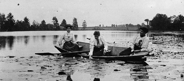 3 ladies in a small boat black and white photo
